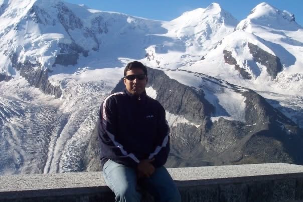 Gagan seated in front of a glacier and snowy peaks