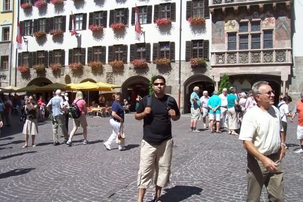 Gagan with his backpack in a flower-lined town square