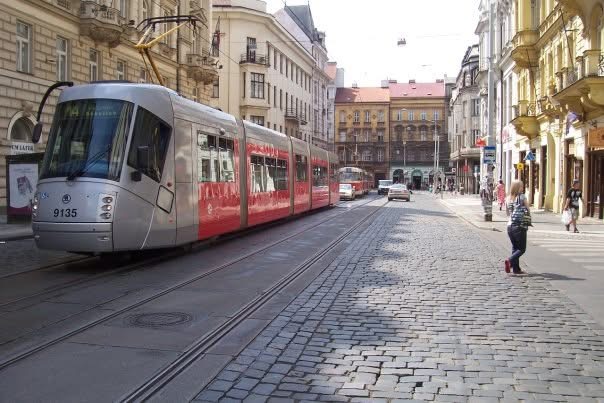 A tram passing through a cobbled European street