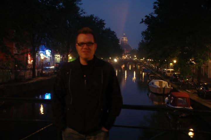 A fellow traveller beside an Amsterdam canal at dusk