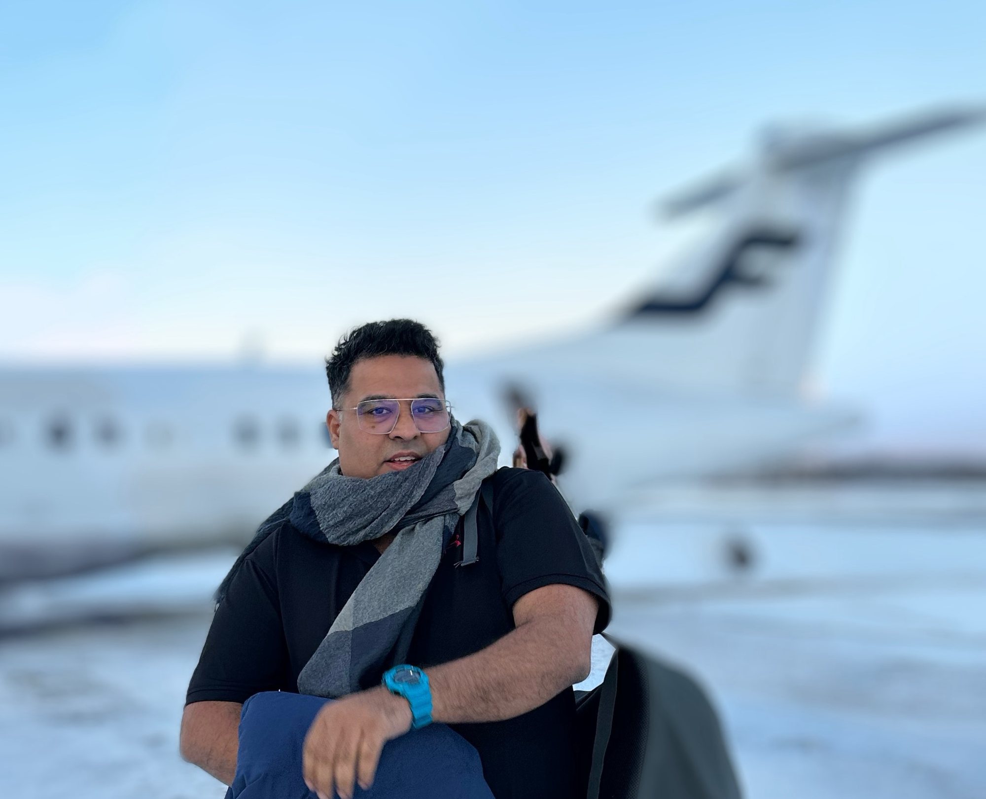 Gagan seated near an aircraft