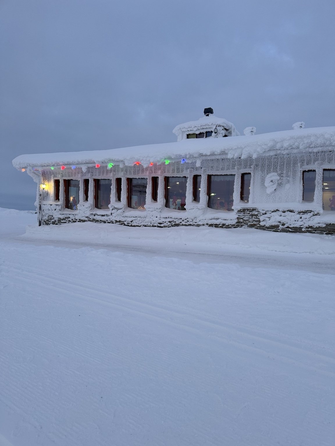 Low building beneath a deep layer of snow