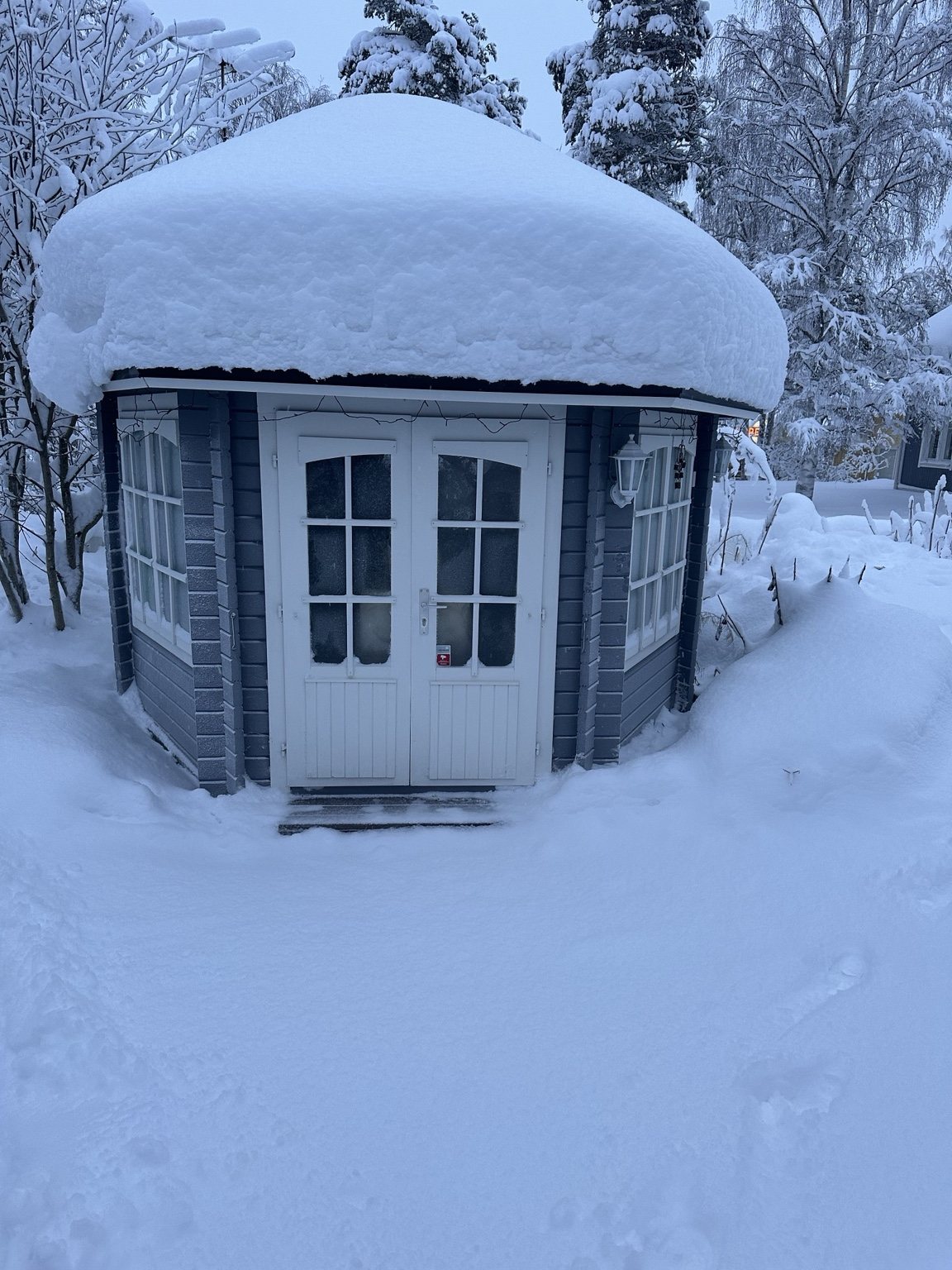 Small cabin under a thick blanket of snow