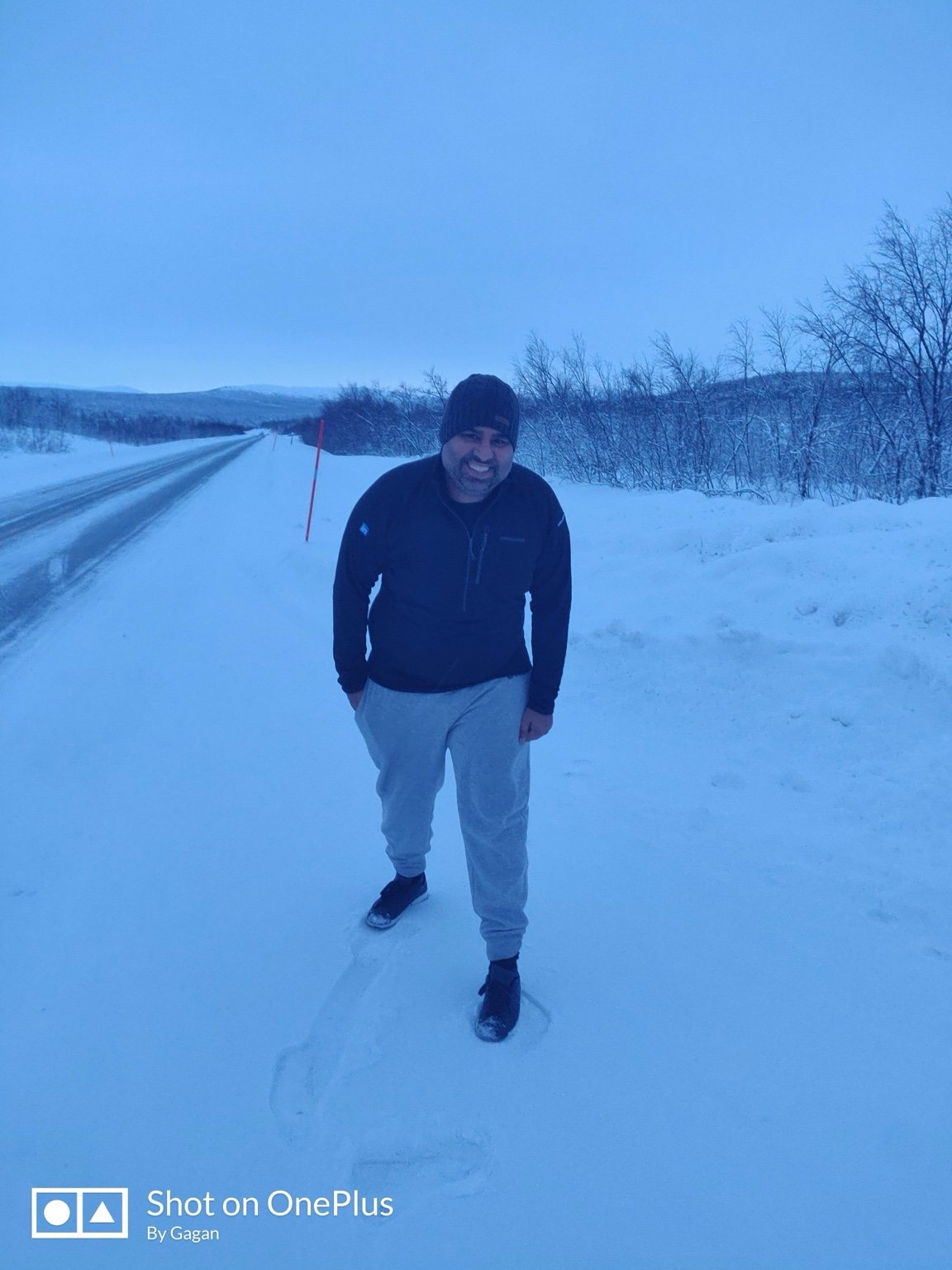 Gagan standing in snow beside a road