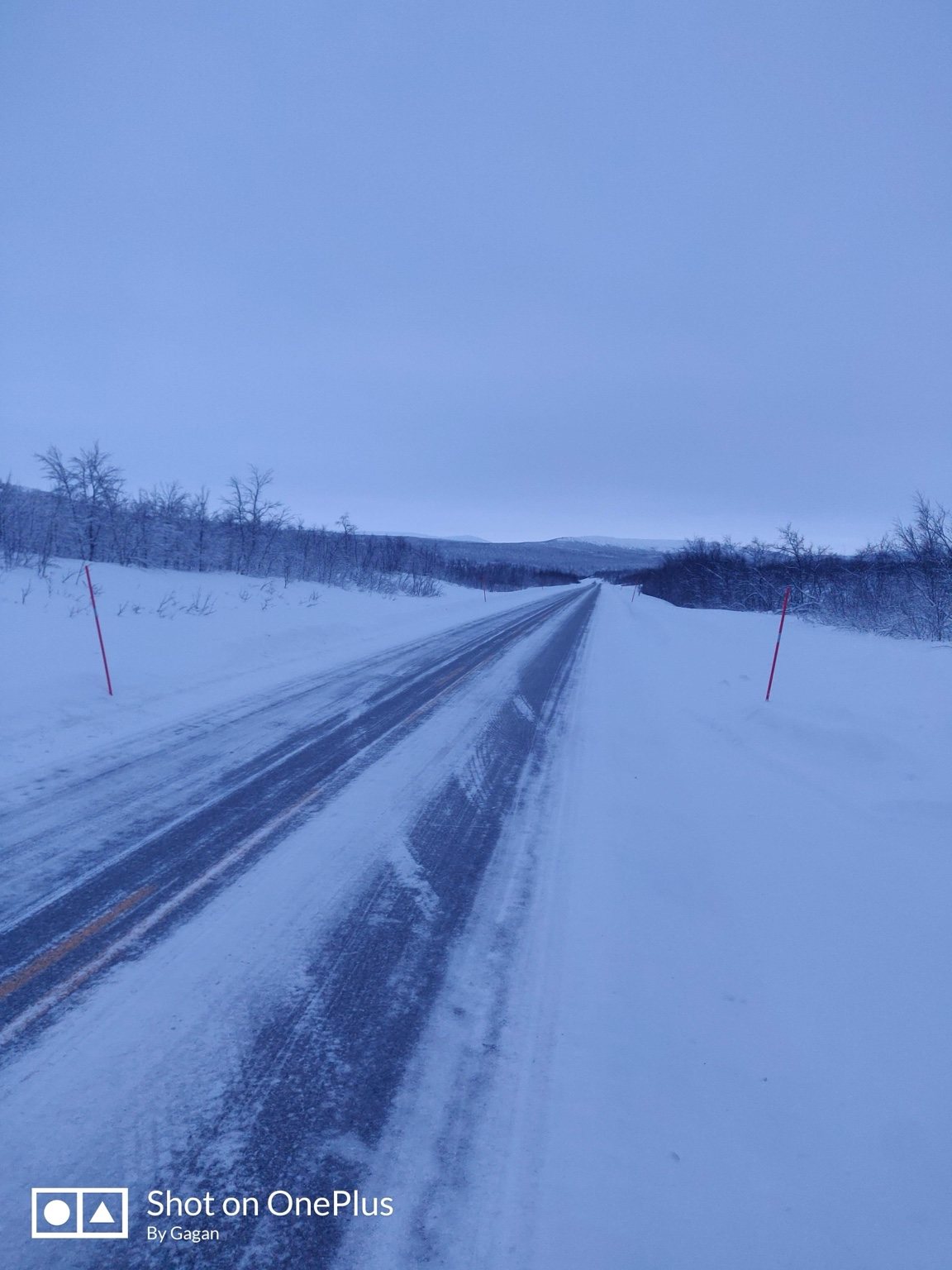Winter road crossing an open snowy landscape