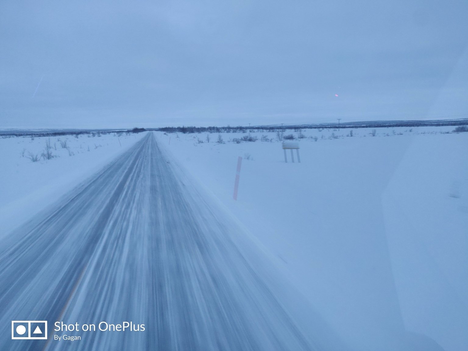 Road disappearing across a snowy plain