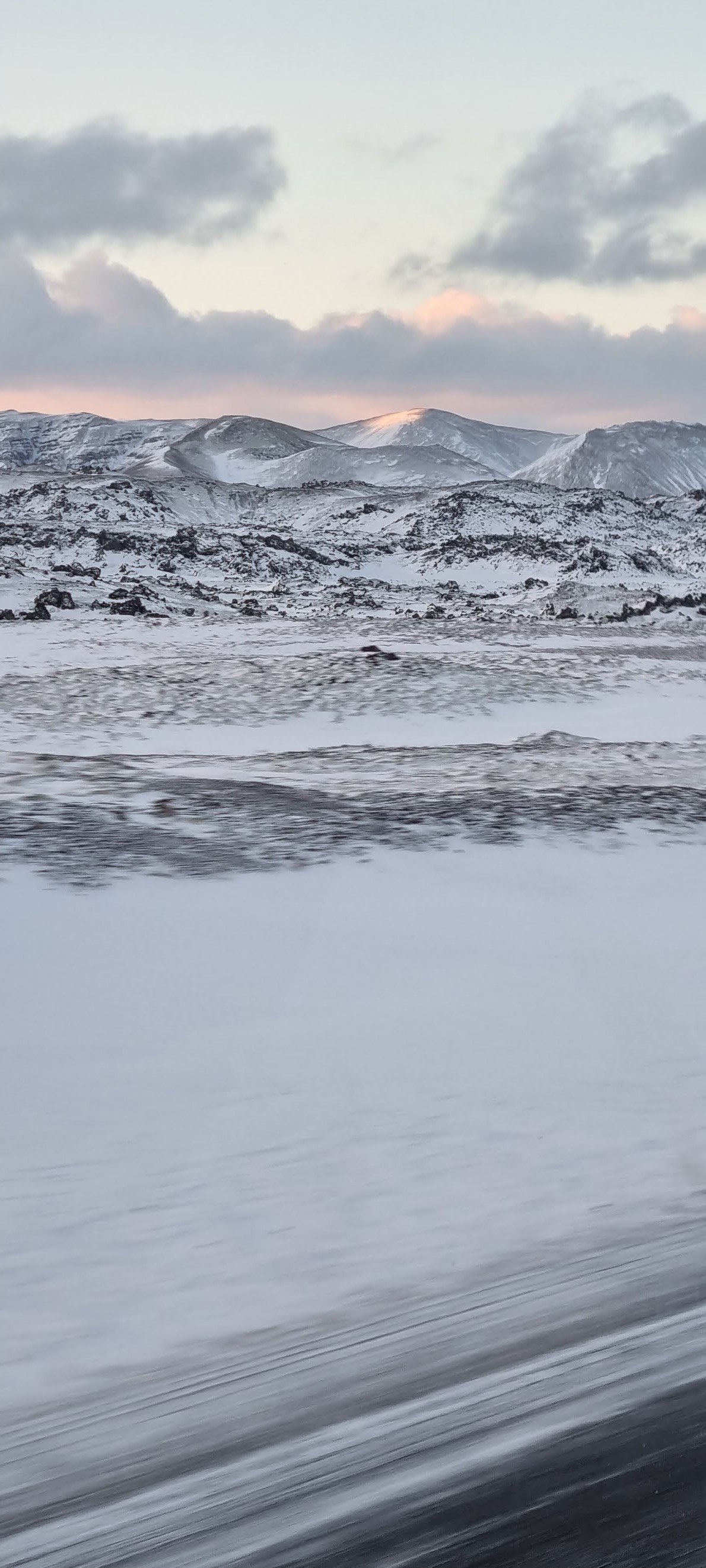 Snow-covered hills beneath a pale winter sky
