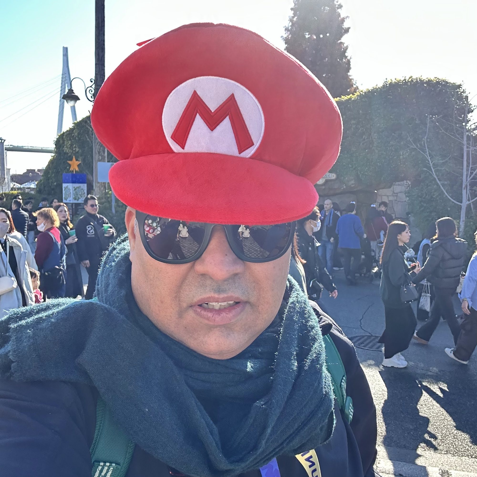 Gagan wearing a red character cap at an amusement park