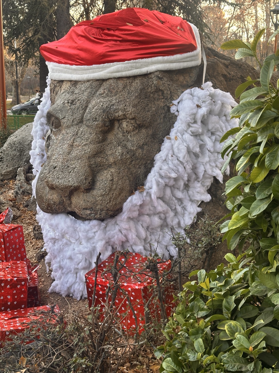 Stone sculpture dressed for Christmas in a red cap and white beard