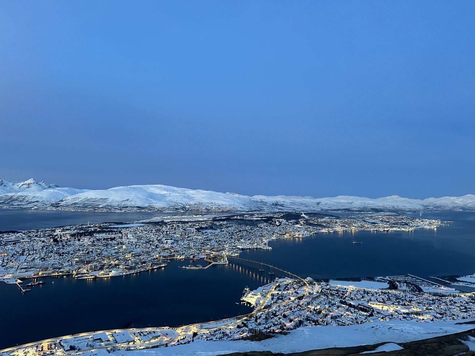 Aerial view over a Norwegian fjord and snowy city