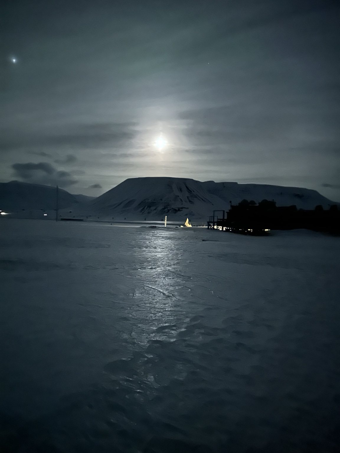 Moonlight over an icy shore and mountains