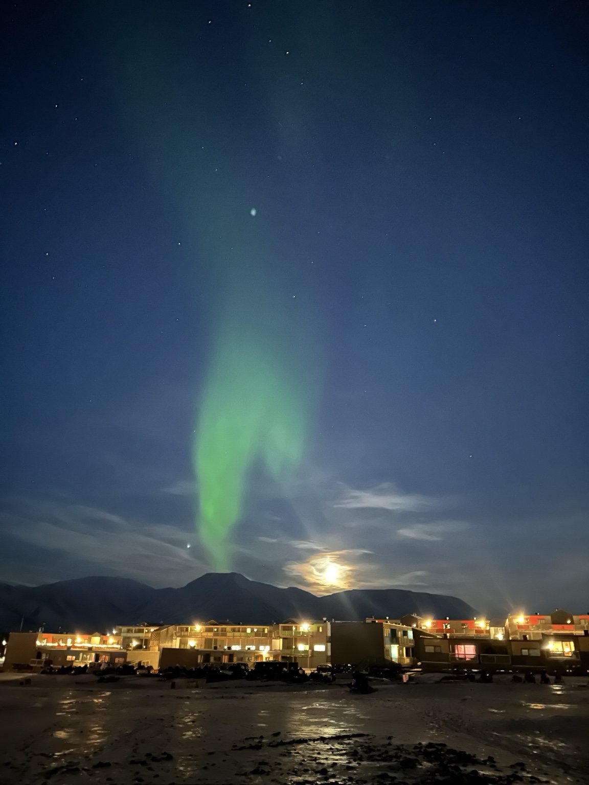 Northern lights above a Svalbard town at night